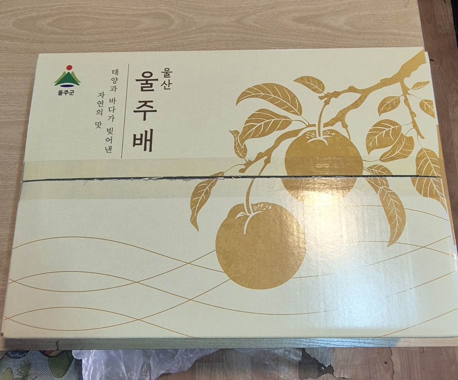 황금빛 배와 잎 무늬, 울산 울주배 글자가 인쇄된 실제 전용 상자의 겉포장